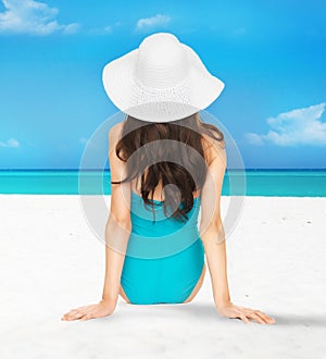Model posing in swimsuit with hat