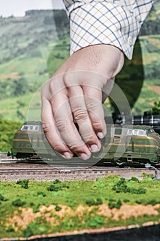 Model railroad. Hand placing locomotive.