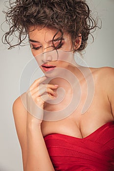 Model in red dress pose touching her chin