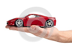 Model of a red sports car in hand on a white background