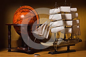 Model sailing ship and old globe