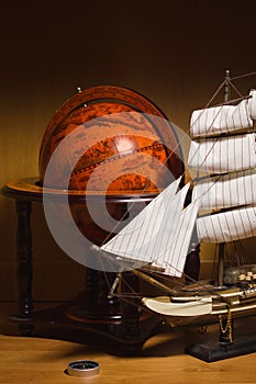 Model sailing ship and old globe