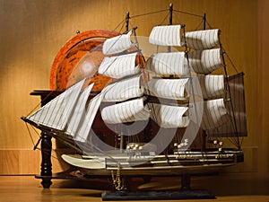 Model sailing ship and old globe