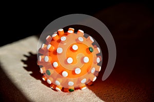 Red bright spiny ball isolated on dark background. Toy, close-up. Coronavirus model.model of the SARS-CoV-2 virus ,toy