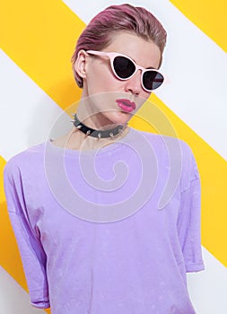 Model with short hair wearing casual summer look and stylish accessories agressive choker and sunglasses. Trendy everyday street