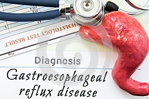 Model of stomach, blood test and stethoscope lying near title diagnosis Gastroesophageal reflux disease. Concept photo of causes, photo