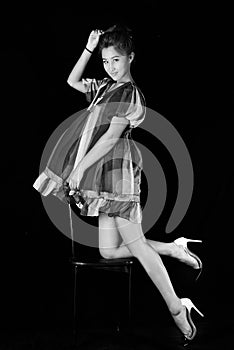 Model in striped dress possing in studio. Black background, Black-white photo,