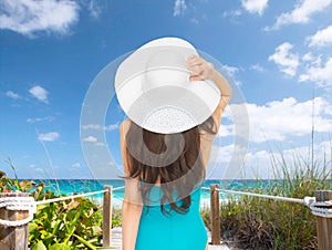 Model in swimsuit with hat