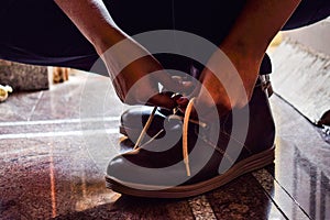 Model tiding laces of his brown color boots