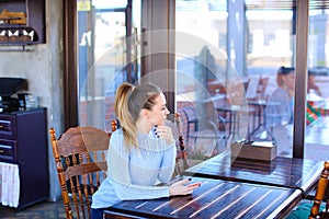 Model waiting photographer for photoshoot in cafe