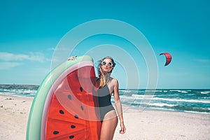 Model with watermelon lilo at the beach