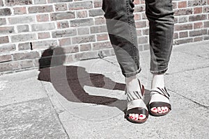 Model wearing black and white sandals with zebra print.