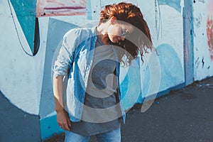 Model wearing plain tshirt and sunglasses posing over street wall