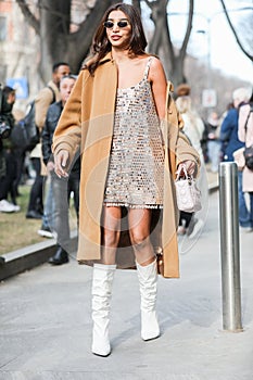 Model wears a sequined dress, a brown overcoat and a pair of white boots during the Armani fashion show at the women`s fashion wee