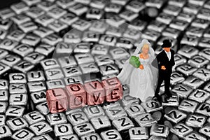 Model wedding couple standing on letter jewellery beads