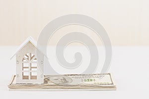 Model white house on hundred dollars banknote. Property investment and house mortgage financial concept,