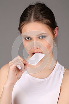 Model in white singlet bitting card. Close up. Gray background