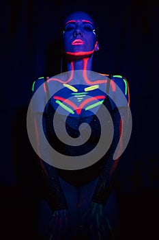 Model woman in neon light, beautiful model girl with fluorescent makeup, art design of disco dancer dancing in uv light