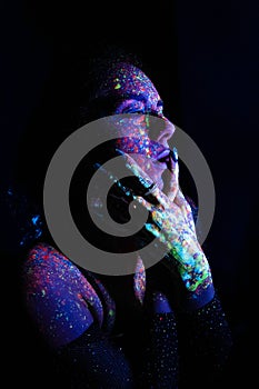 Model woman in neon light, beautiful model girl with fluorescent makeup, art design of disco dancer dancing in uv light