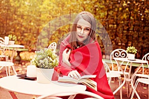 Model Woman Reading a Book in a Cafe Outdoors