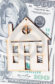 Model of wooden house with dollar bills. House building, loan, real estate, cost of housing or buying a new home concept.