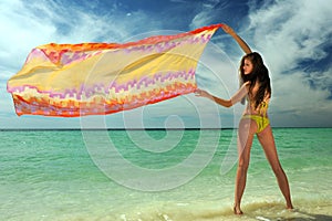 Model in yellow bikini holding pareo