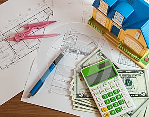 Modelhouse, calculator and US Dollars on construction planning