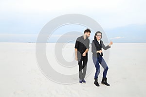 models man and woman jumping for joy at seaside.