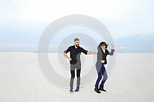 models man and woman jumping for joy at seaside.