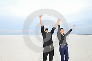 models man and woman jumping for joy at seaside.