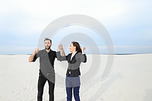 models man and woman jumping for joy at seaside.