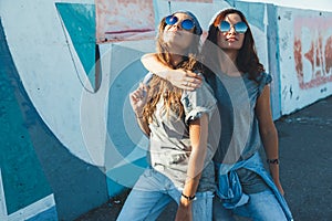 Models wearing plain tshirt and sunglasses posing over street wa