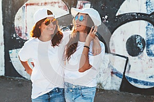 Models wearing plain tshirt and sunglasses posing over street wa