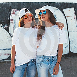 Models wearing plain tshirt and sunglasses posing over street wa photo