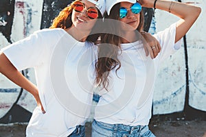 Models wearing plain tshirt and sunglasses posing over street wa photo