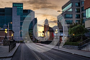 Moder and vintage buildings architecture. Illuminated street lamps at sunset on George Dock Street, Ireland