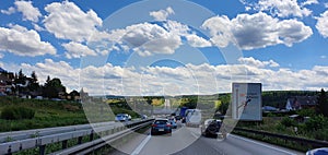 Moderately frequented motorway with moving vehicles against blue sky photo