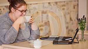 Moderately obese businesswoman sitting in a cafe while holding coffee