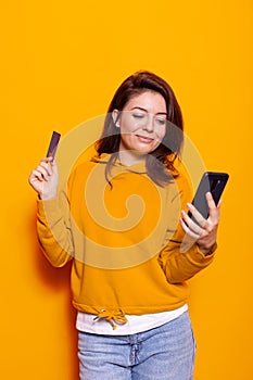 Modern adult holding credit card to make purchase online