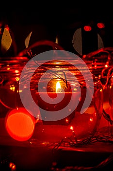 Modern advent wreath made of four glass jars, fake snow and red candles. Christmas decoration