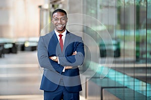 Modern African American CEO portrait standing confidently, with arms crossed, at swanky luxurious office building