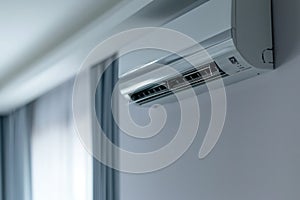 Modern air conditioner on white wall with soft focus background, symbolizing comfort and coolness