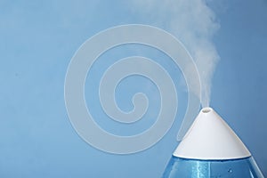 Modern air humidifier on blue background, closeup. Space for text