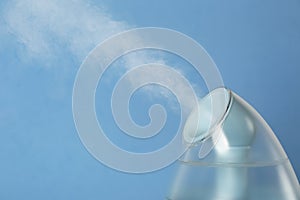 Modern air humidifier on blue background, closeup. Space for text