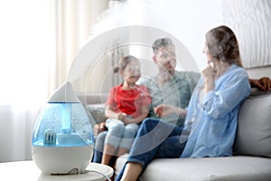 Modern air humidifier and blurred family