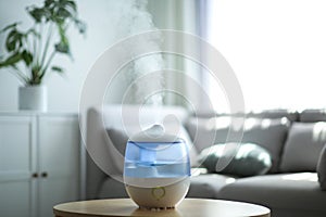 Modern air humidifier on table in room