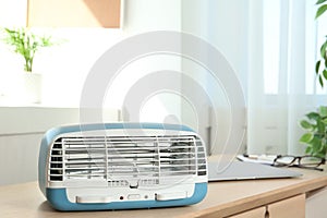 Modern air purifier on table in room