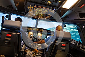 Modern airbus airplane cockpit with pilots during a training session in a full flight simulator