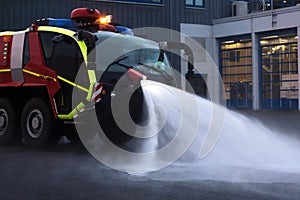 Modern airport fire department fire engine clears with water