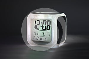 Modern alarm clock glowing light on dark backdrops and copyspace. LED light or digital display